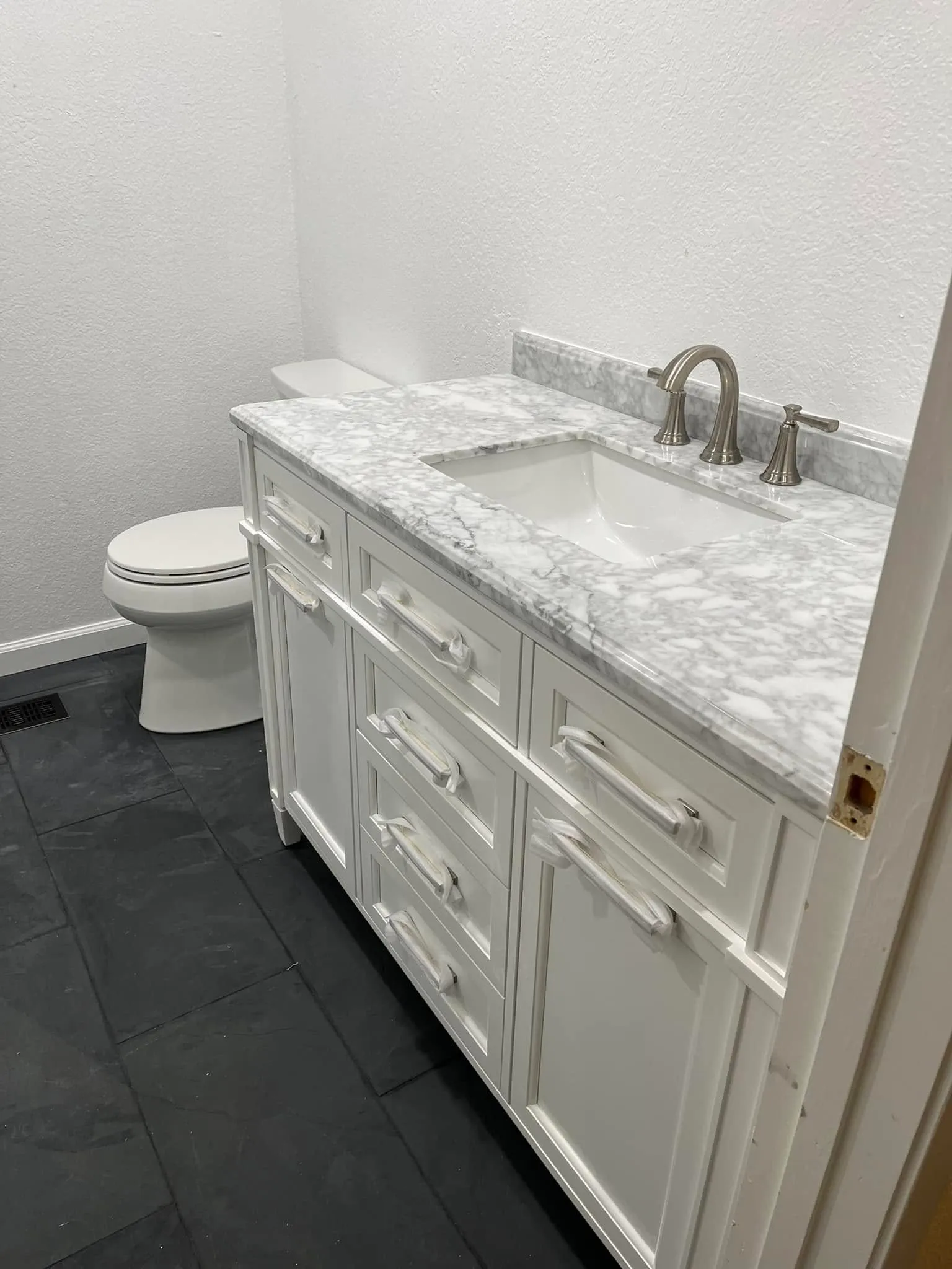 White bathroom vanity with a marble top in a Vallejo remodel