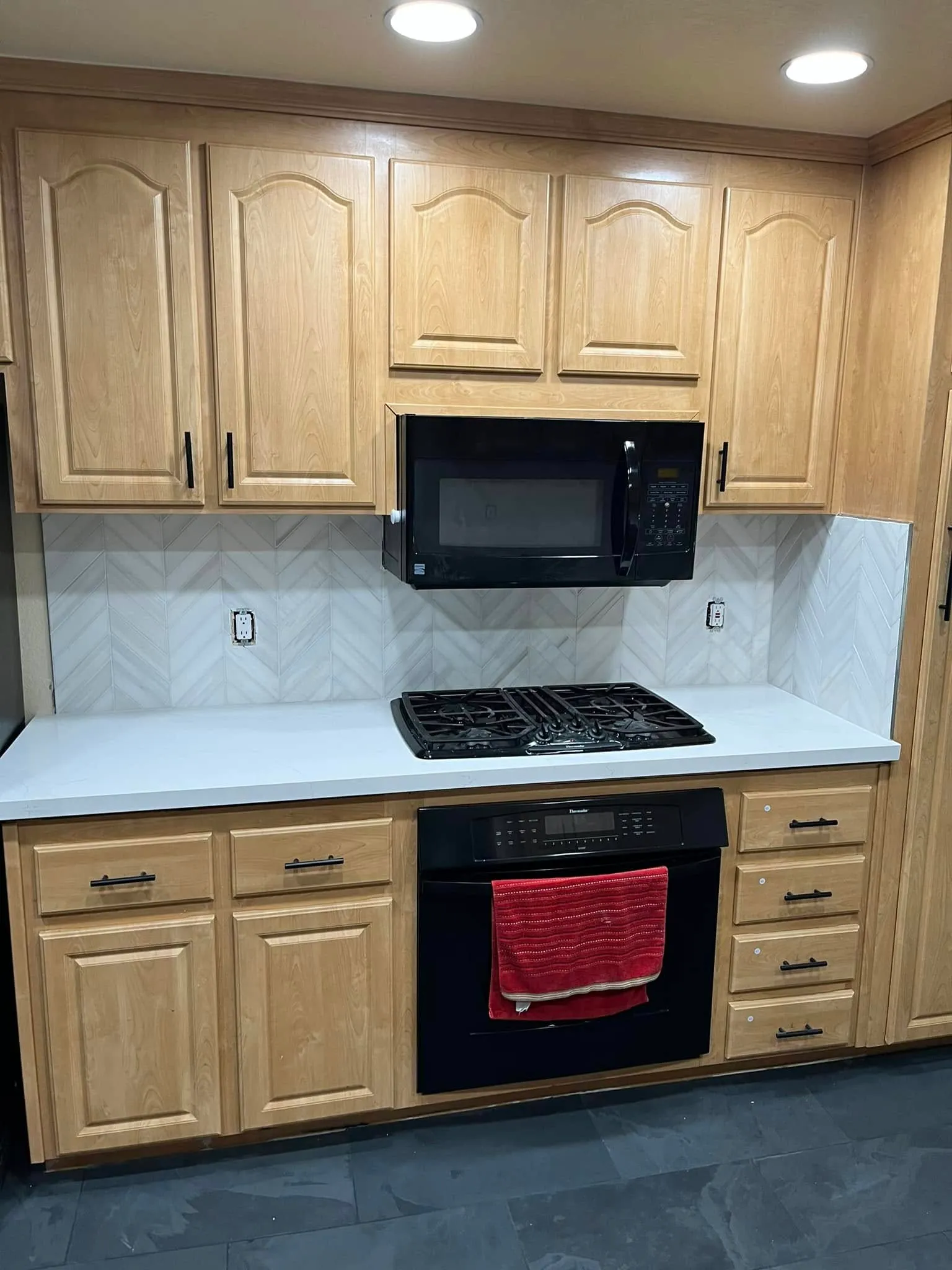 Honey oak cabinets with a herringbone backsplash and quartz counters in Vallejo