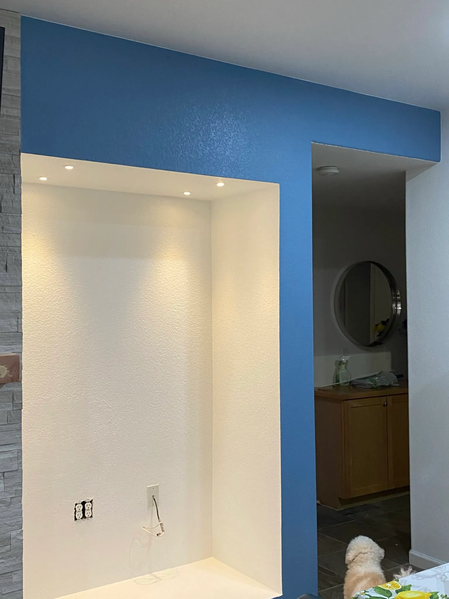 Blue accent wall and recessed lit niche, freshly painted in Vallejo