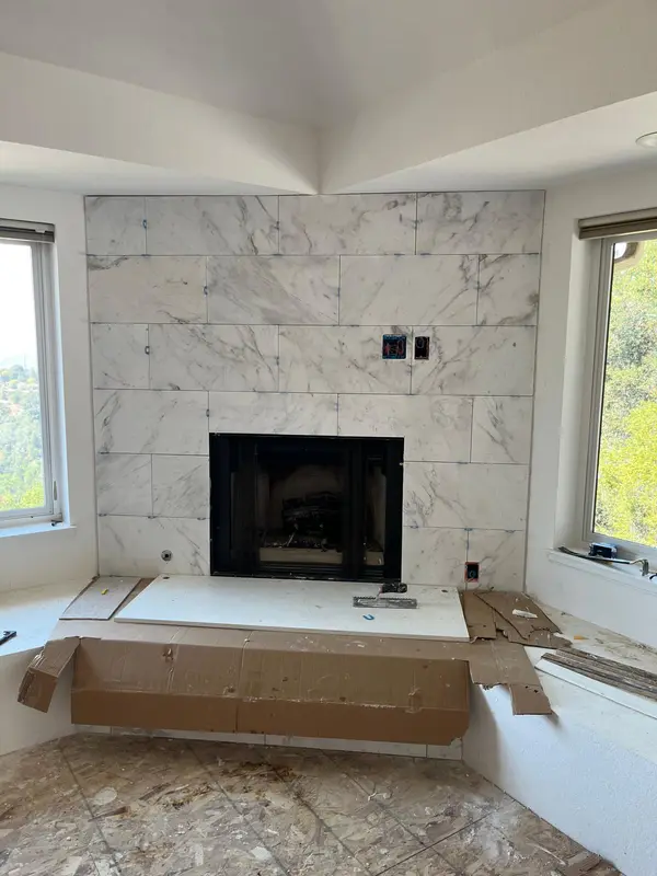 Home remodeler in Vallejo setting large-format marble tile around a fireplace