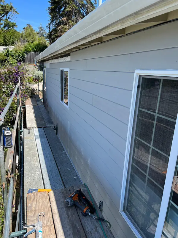 Exterior painting in Vallejo: freshly painted gray lap siding and white window trim